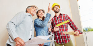 Des professionnels de l'habitat entourant un particulier sur son chantier de maison