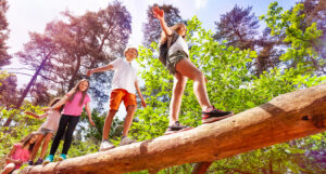 Des enfants marchent sur un tronc d'arbre coupé