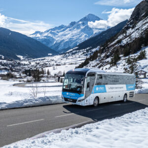 Un bus HMV circulant sur une route de montagne